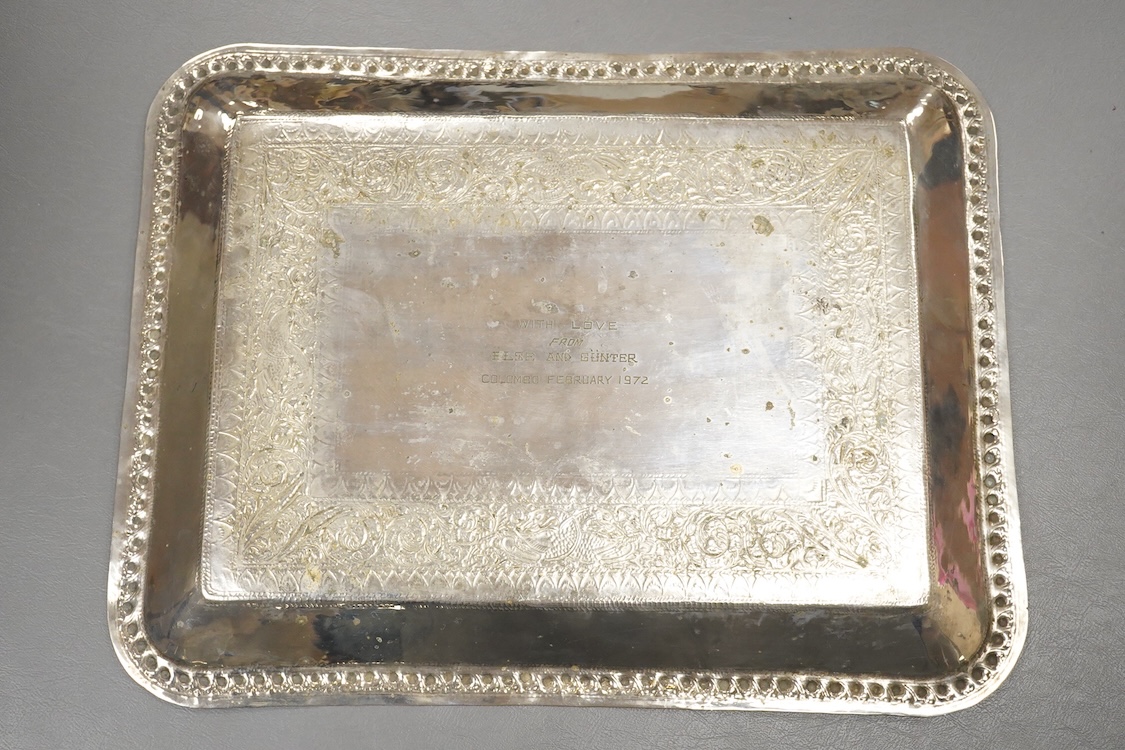 A 20th century Indian colonial white metal tray, with engraved decoration and personal inscription to the base, 39.6cm, 21.1oz.
